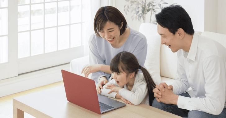 親子3人でノートPCに向かい楽しんでいるイメージ